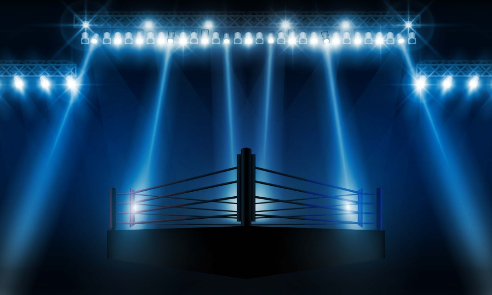 Spotlights illuminating a dark and empty boxing arena.