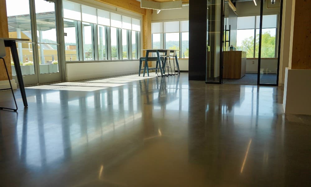 A highly polished concrete floor with excellent reflections of light and windows.